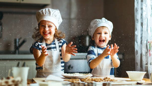 happy family  funny kids are preparing the dough, bake cookies in the kitchen